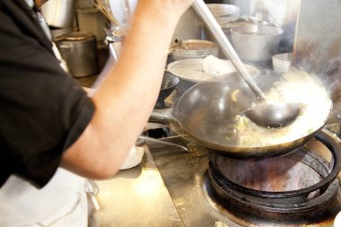 Aşçı mutfakta kızartma yapıyor.