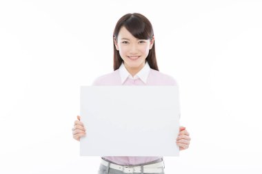 Tecrit edilmiş arka planda boş tahtası olan genç Asyalı iş kadını. 