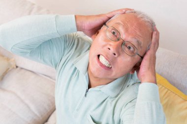 Kanepesindeki kızgın yaşlı adamın portresi.