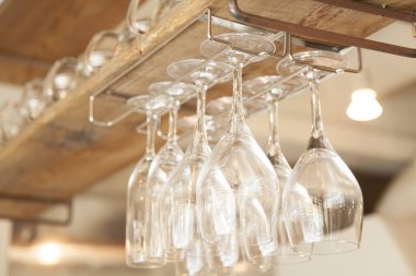 Bar rafında asılı boş şarap kadehleri.