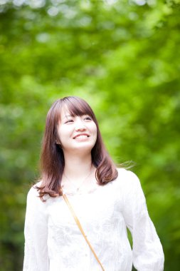 Parkta beyaz elbiseli güzel Asyalı kadın.