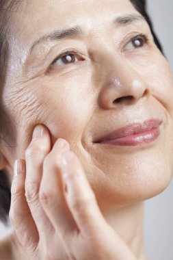 Asyalı kadın yüzü, yakın plan, beyaz arka plan, cilt bakımı konsepti