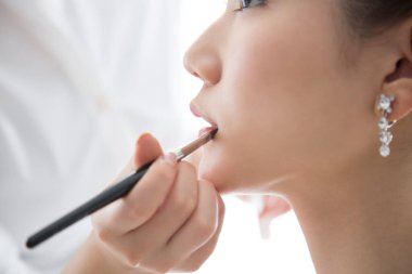 Gelin düğün günü güzellik salonuna ruj sürmeye hazırlanıyor. 