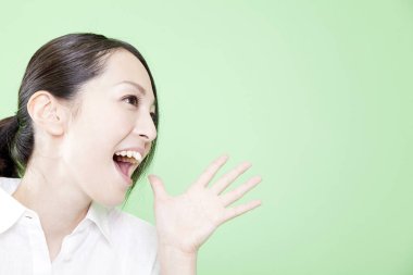 Asyalı kadın portresi. Yeşil arka planda şaşırmış bir ifade var. Asyalı kadın.