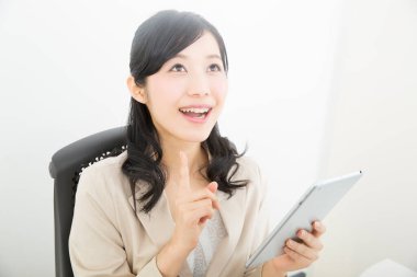 Ofiste tablet bilgisayar kullanan Asyalı kadın. 