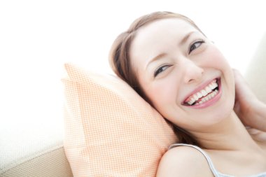 Evdeki kanepede gülümseyen kadın, yakın çekim..