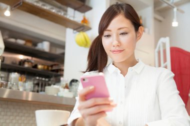 Kafede cep telefonu kullanan kadın 