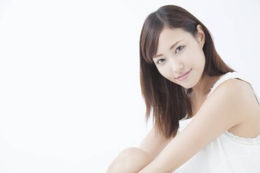 Genç, güzel Asyalı bir kadın izole edilmiş arka planda kameraya bakıyor.  