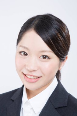 Genç iş kadını beyaz kameraya bakıyor.