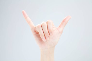 Beyaz arka planda el hareketi yapan kadınların yakın çekimi. 