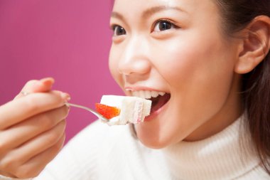 jonge vrouw eten aardbei taartÇilekli pasta yiyen genç kadın