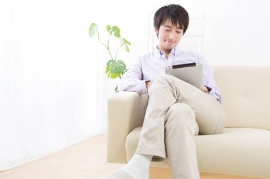 Kanepede tabletli genç adam. 