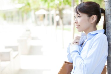 Parkta düşünen Asyalı kadın.