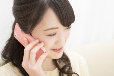 Akıllı telefondan konuşan gülümseyen Asyalı kadın, yakın plan portre 