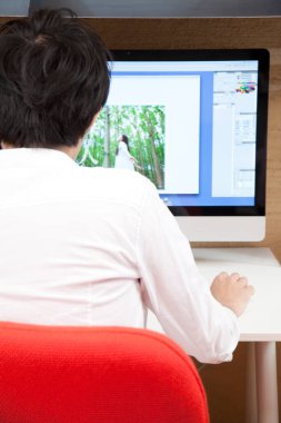 İşadamı ofiste bilgisayarla çalışıyor.