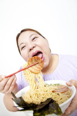 Şişman Asyalı kadın erişte yiyor. Stüdyo resmi