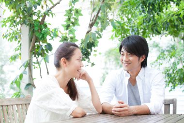 Kafede birbirine aşık genç Asyalı çift oturuyor..