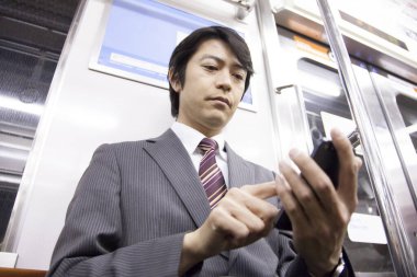 Yetişkin Japon iş adamının portresi metroda çalışacak.