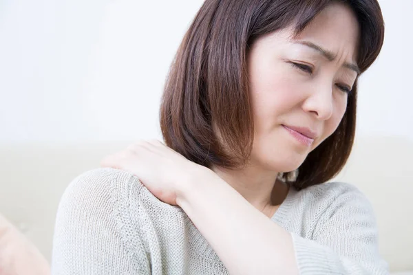 年轻的亚洲女人在家里脖子疼 — 图库照片