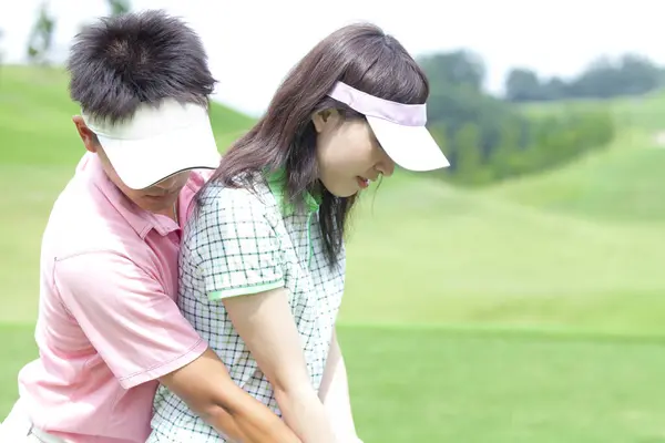 ゴルフをする若い日本のカップル — ストック写真