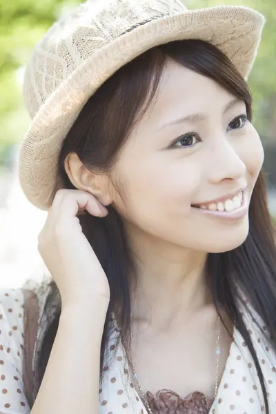 stock image beautiful smiling Asian woman in hat posing on street