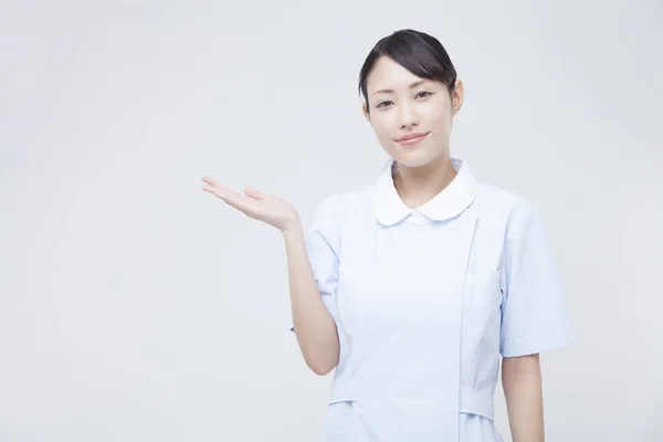 Junge Krankenschwester Zeigt Etwas Auf Der Handfläche — Stockfoto