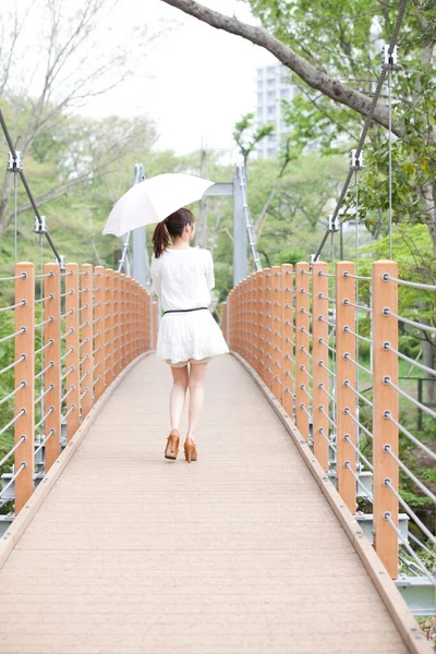young beautiful woman walking on  bridge  in the park