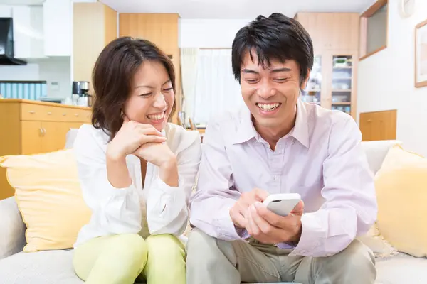 Mutlu Genç Çift Evde Akıllı Telefon Kullanıyor — Stok fotoğraf