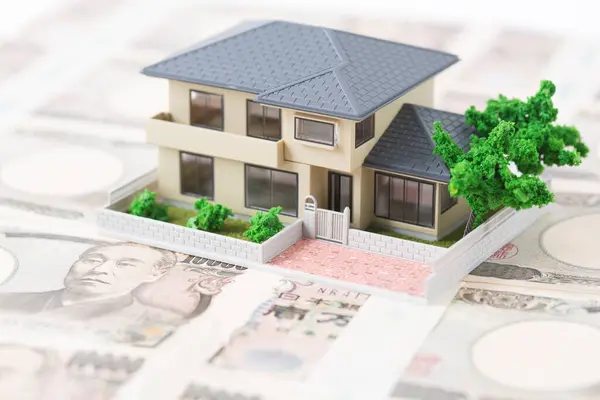 背景上孤立的有日元钞票的模范房子 — 图库照片