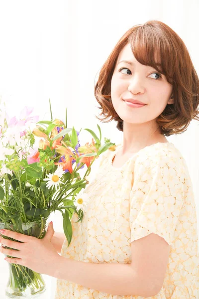 新鮮な花の花束で笑顔の若い日本の女性 — ストック写真