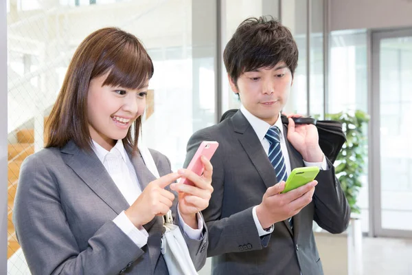 stock image business woman and business man  using smartphones in office 