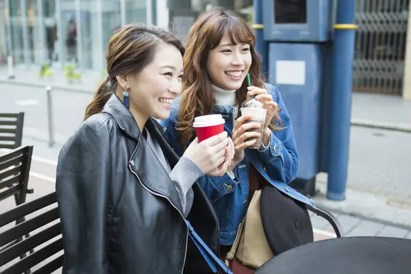 asian young woman friends drinking coffee in city