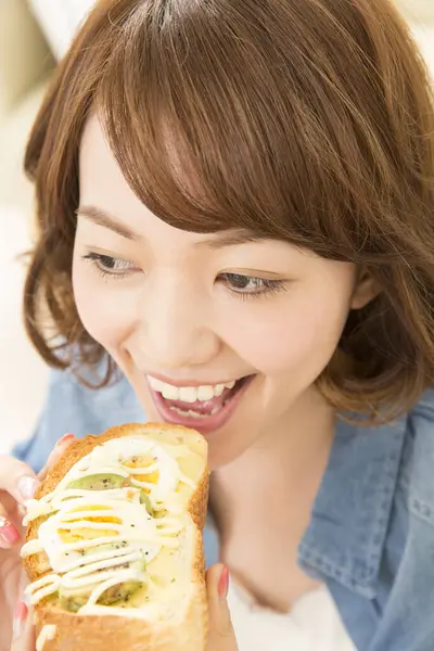 自宅でサンドイッチを食べる美しい日本人女性 — ストック写真