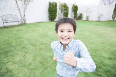 Mutlu çocuk çimenlerde oynuyor. 