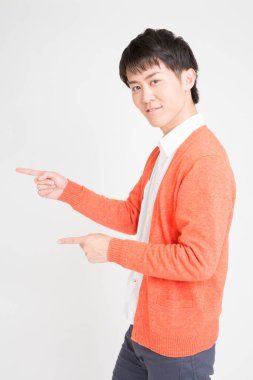 Asyalı adam beyaz arkaplanı işaret ediyor..