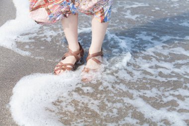 Kumsalda uzun etek giyen genç bir kadının alçak görünümü