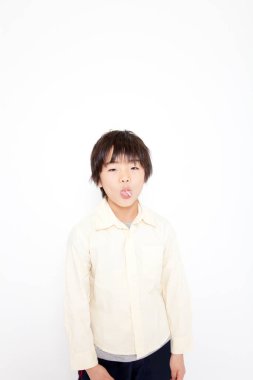 Beyaz arka planda şeker taşıyan Asyalı çocuk.