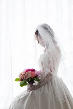 Bir buket çiçekli güzel gelinin portresi