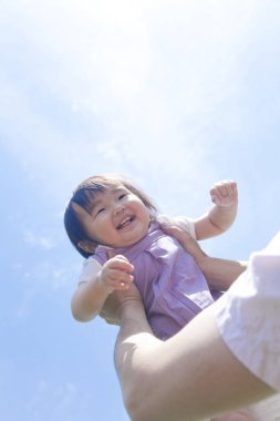 Mavi gökyüzü geçmişi olan mutlu Asyalı kız.