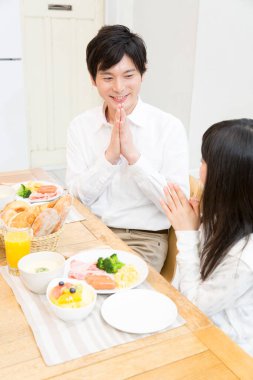 Asyalı aile birlikte kahvaltı yapıyor, baba ve kız. 