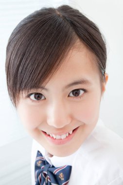 Okul üniformalı genç Japon kızın stüdyo portresi.