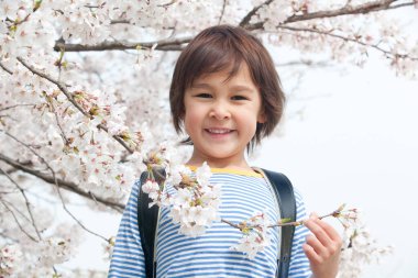 Bahar parkında sırt çantalı yakışıklı Japon çocuk. Eğitim kavramı