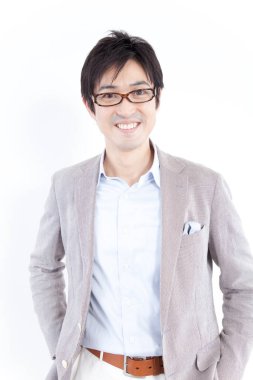 Gözlüklü gülümseyen Japon işadamının stüdyo portresi.