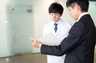 Doktor ve iş adamı ofiste tartışıyor. 