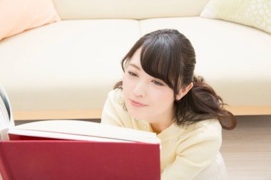 Evde kitap okuyan güzel Asyalı kadın