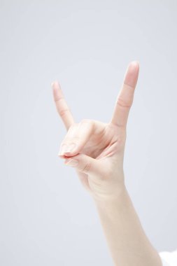 Beyaz arka planda el hareketi yapan kadınların yakın çekimi. 