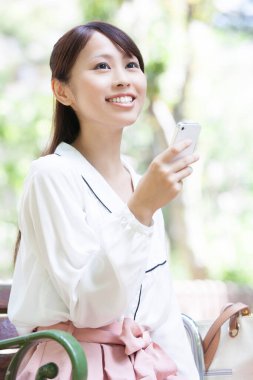 Sokakta akıllı telefon kullanan güzel Japon kadın.