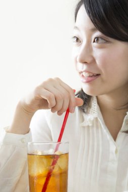 Elinde içkiyle masada oturan bir kadın.