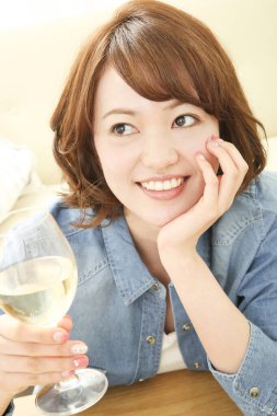 Evde şarap içen Asyalı kadının portresi.