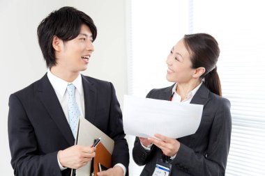 Gülümseyen ofis çalışanları iş belgelerini tartışıyorlar. Takım çalışması konsepti